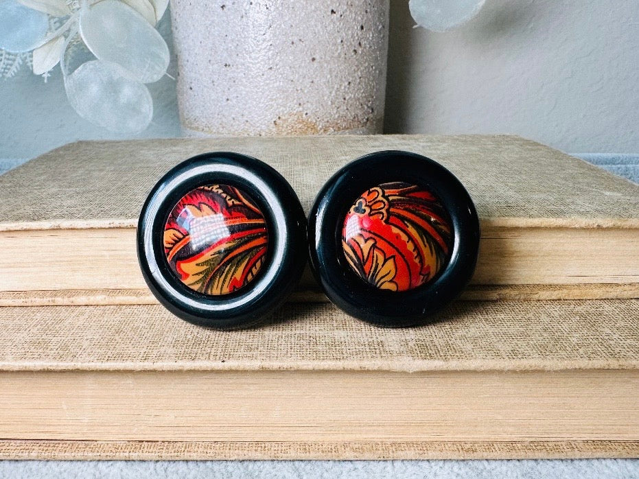 These big and bold 1980s acrylic earrings are so fun. Oversized circles with a solid black border and colorful mottled red and orange paisley printed center- pierced style. Great vintage condition- please see pics. More fun vintage pairs available!
Dimensions: about 1.25" diameter See additional pics for visual reference.