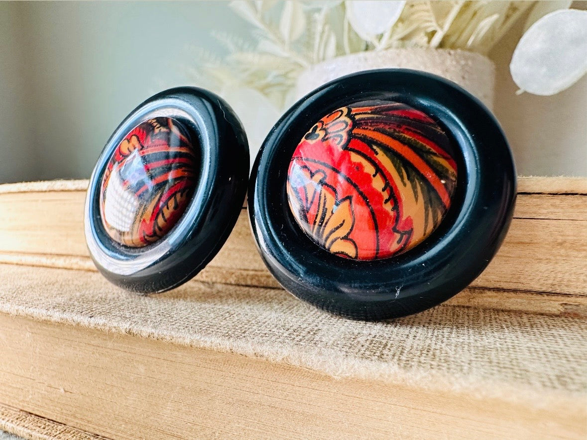These big and bold 1980s acrylic earrings are so fun. Oversized circles with a solid black border and colorful mottled red and orange paisley printed center- pierced style. Great vintage condition- please see pics. More fun vintage pairs available!
Dimensions: about 1.25" diameter See additional pics for visual reference.