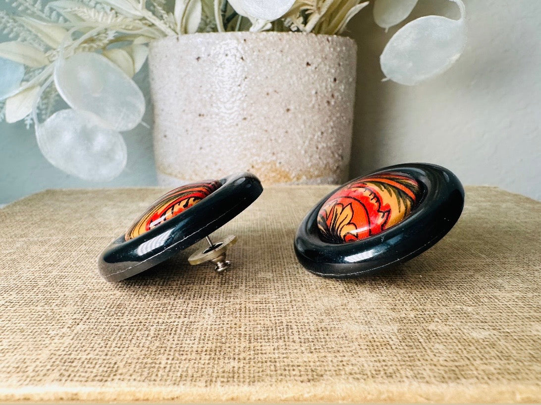 These big and bold 1980s acrylic earrings are so fun. Oversized circles with a solid black border and colorful mottled red and orange paisley printed center- pierced style. Great vintage condition- please see pics. More fun vintage pairs available!
Dimensions: about 1.25" diameter See additional pics for visual reference.