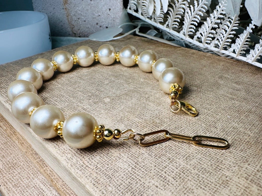 This classic pearl bracelet is handmade with gorgeous champagne pearls, gold filigree accents, and 18K hardware. The gold accents paired with the creamy champagne pearls are a classic and timeless design. This bracelet looks fantastic worn alone- or stack it with others to make a statement. This bracelet is made to order. Please select your desired base length at check out- a 1.5" extension will be added to easily customize the fit. Lobster clasp closure. A beautiful pearl bracelet- matching earrings are
