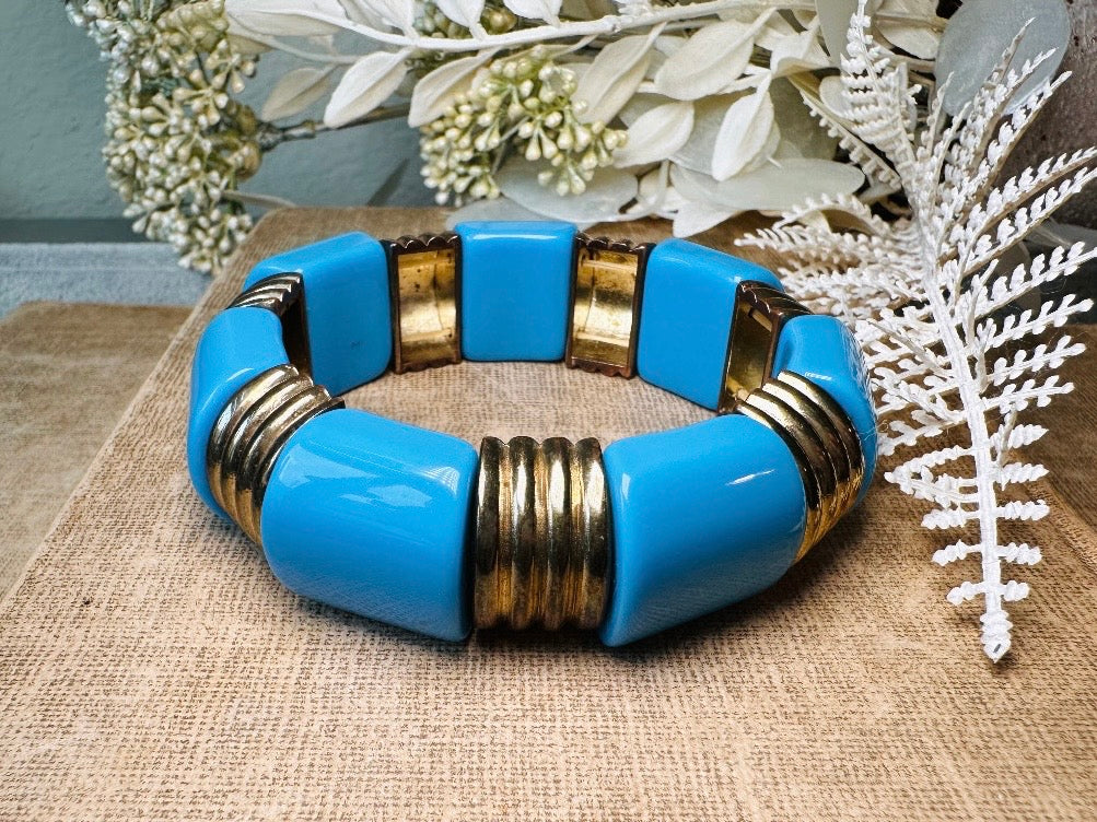 This vintage bright blue and bronzed gold chunky stretch bracelet is a fun blast from the past. This colorful geometric bracelet is full of contrast. An awesome pop of color for everyday wear, or pair it with others for the ultimate bracelet stack. In great vintage condition- please see all pics.
Dimensions: band is 1" wide. stretch style will fit most.