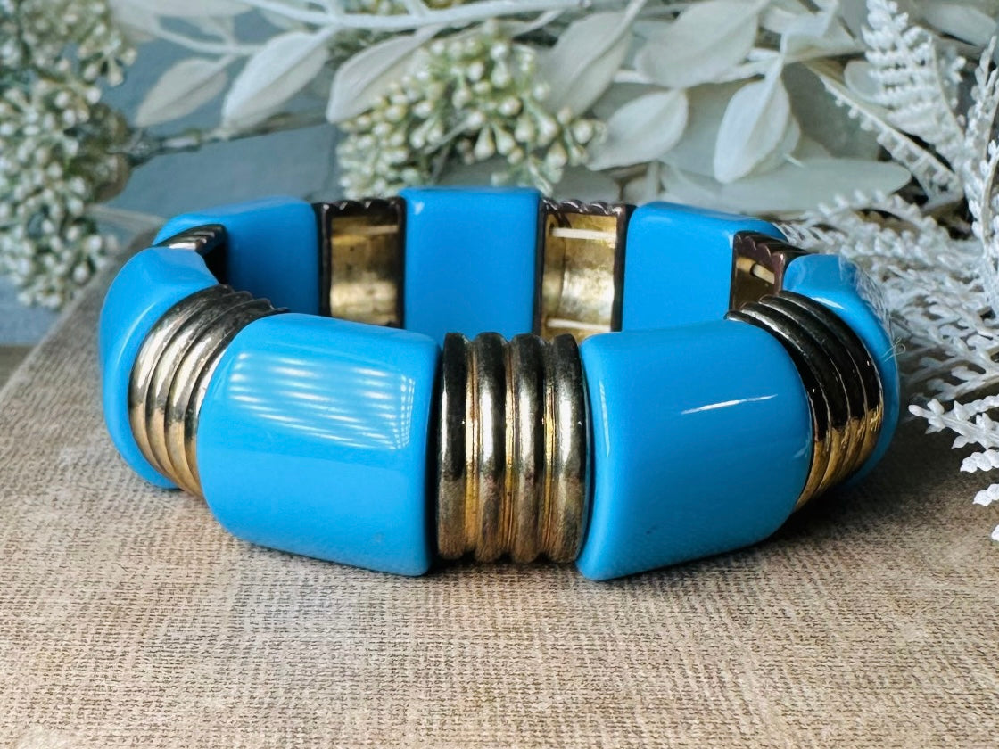 This vintage bright blue and bronzed gold chunky stretch bracelet is a fun blast from the past. This colorful geometric bracelet is full of contrast. An awesome pop of color for everyday wear, or pair it with others for the ultimate bracelet stack. In great vintage condition- please see all pics.
Dimensions: band is 1" wide. stretch style will fit most.
