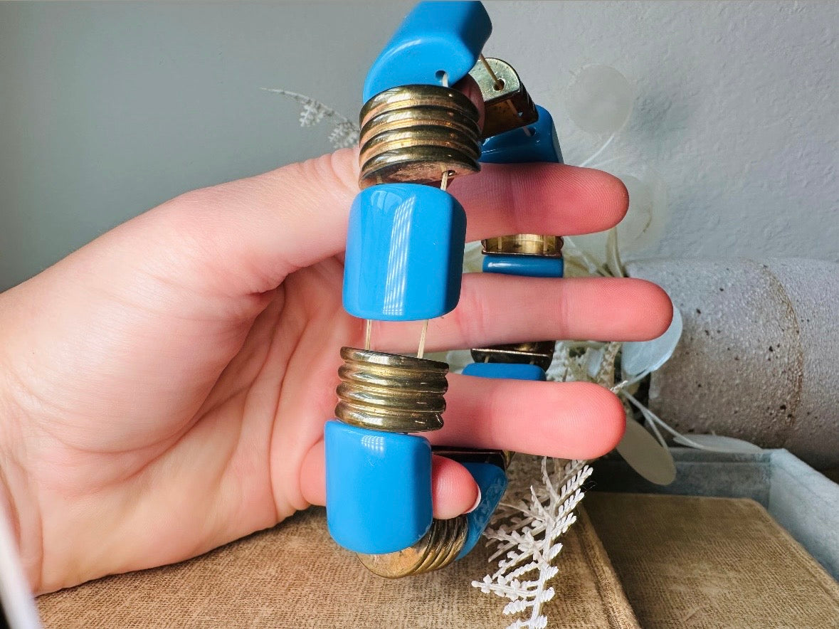 This vintage bright blue and bronzed gold chunky stretch bracelet is a fun blast from the past. This colorful geometric bracelet is full of contrast. An awesome pop of color for everyday wear, or pair it with others for the ultimate bracelet stack. In great vintage condition- please see all pics.
Dimensions: band is 1" wide. stretch style will fit most.