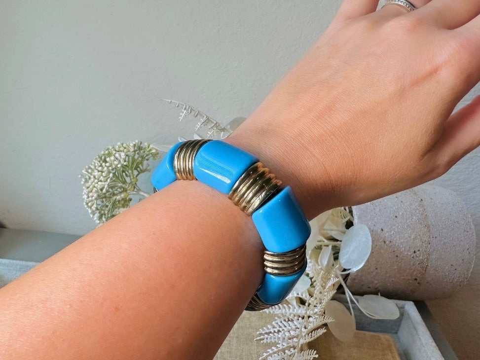 This vintage bright blue and bronzed gold chunky stretch bracelet is a fun blast from the past. This colorful geometric bracelet is full of contrast. An awesome pop of color for everyday wear, or pair it with others for the ultimate bracelet stack. In great vintage condition- please see all pics.
Dimensions: band is 1" wide. stretch style will fit most.