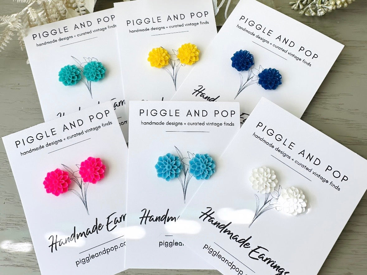 These bright cobalt blue dahlia flower stud earrings are the perfect accent to brighten up your outfit. These handmade glossy resin flower earrings feature hypoallergenic surgical steel posts with butterfly backs- ideal for sensitive ears. These whimsical earrings will arrive beautifully packaged and ready for gift giving (for yourself or another!) at no extra charge.