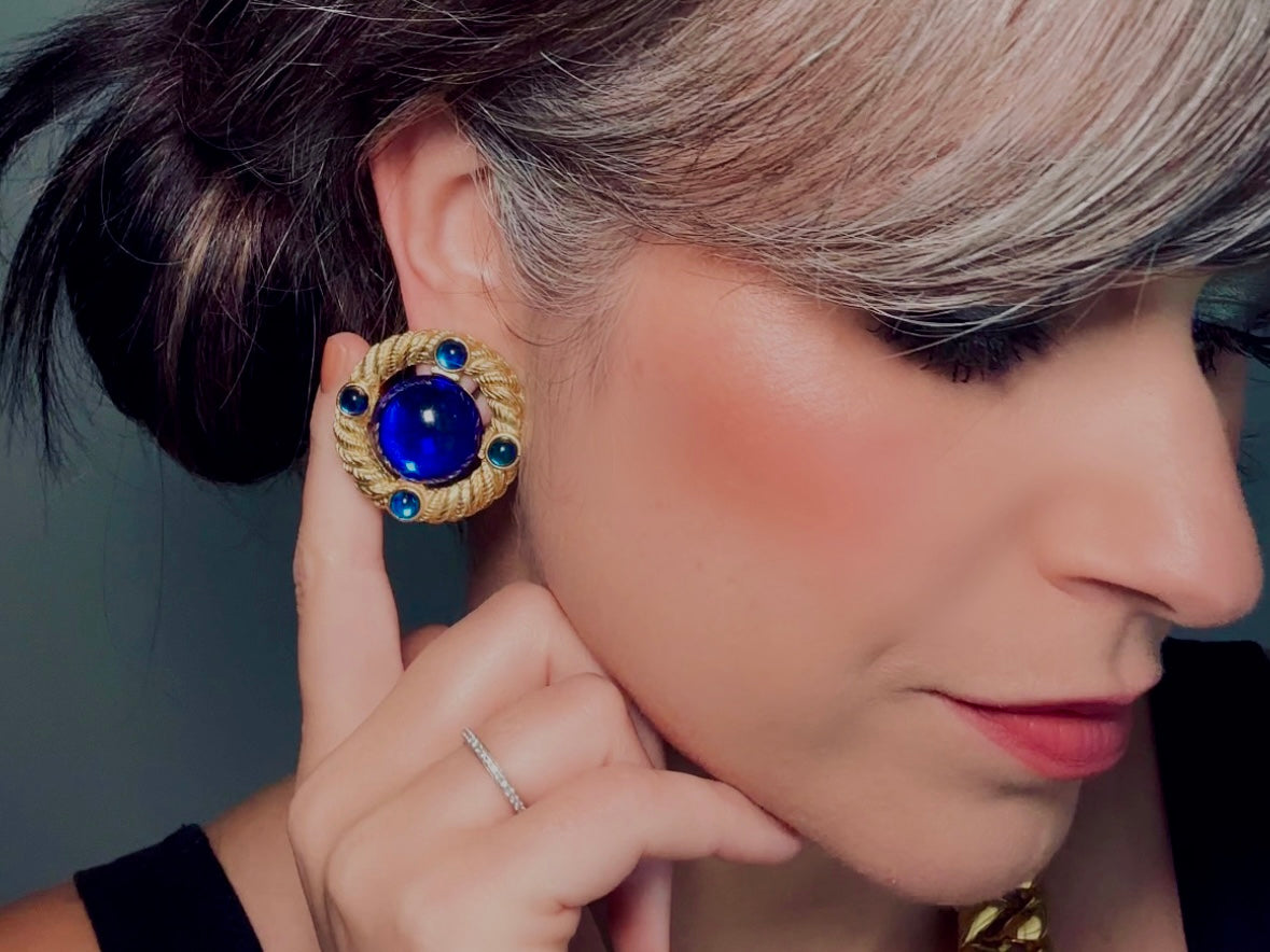 These vintage Park Lane gold rope earrings with cobalt blue cabochons are absolutely out of this world! Vibrant deep blue cabochons glow as they are surrounded by an intricate gold rope border that is accented with four more smaller blue jewels. These stones are so vibrant and vividly pop against their gold setting. Ultimate 80s mega star vibes, post style for pierced ears. Highly collectible signed designer pair in excellent vintage condition, no major flaws to note. modeled for size reference.