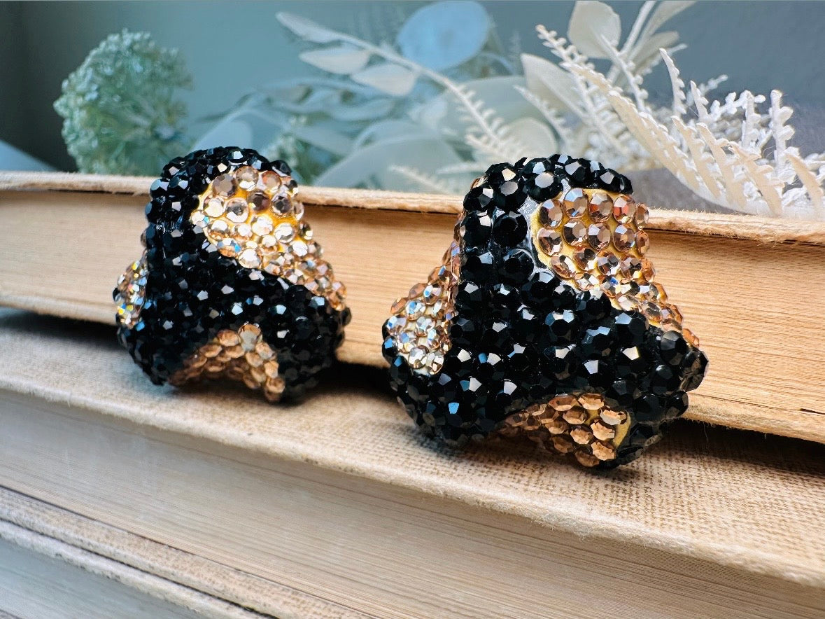 These glamorous vintage Richard Kerr cocktail earrings are spectacular. Sparkling black and gold pave set Swarovski crystals cover the entirety of the earrings, these statement earrings are the height of 80s glam. Featuring a sculptural 3d shape like a knot. The gold component is a rich topaz hue.
Clip on style, in great vintage condition.