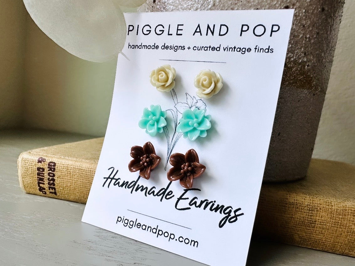 This listing is for three lovely pairs of handmade resin flower earrings. Cream roses, mint lotuses and chocolate brown lilies are paired up in a chic feminine set. These semi- glossy floral earrings are mounted on hypoallergenic surgical steel posts with butterfly backs. Dressed up or down, they are perfect for any occasion!