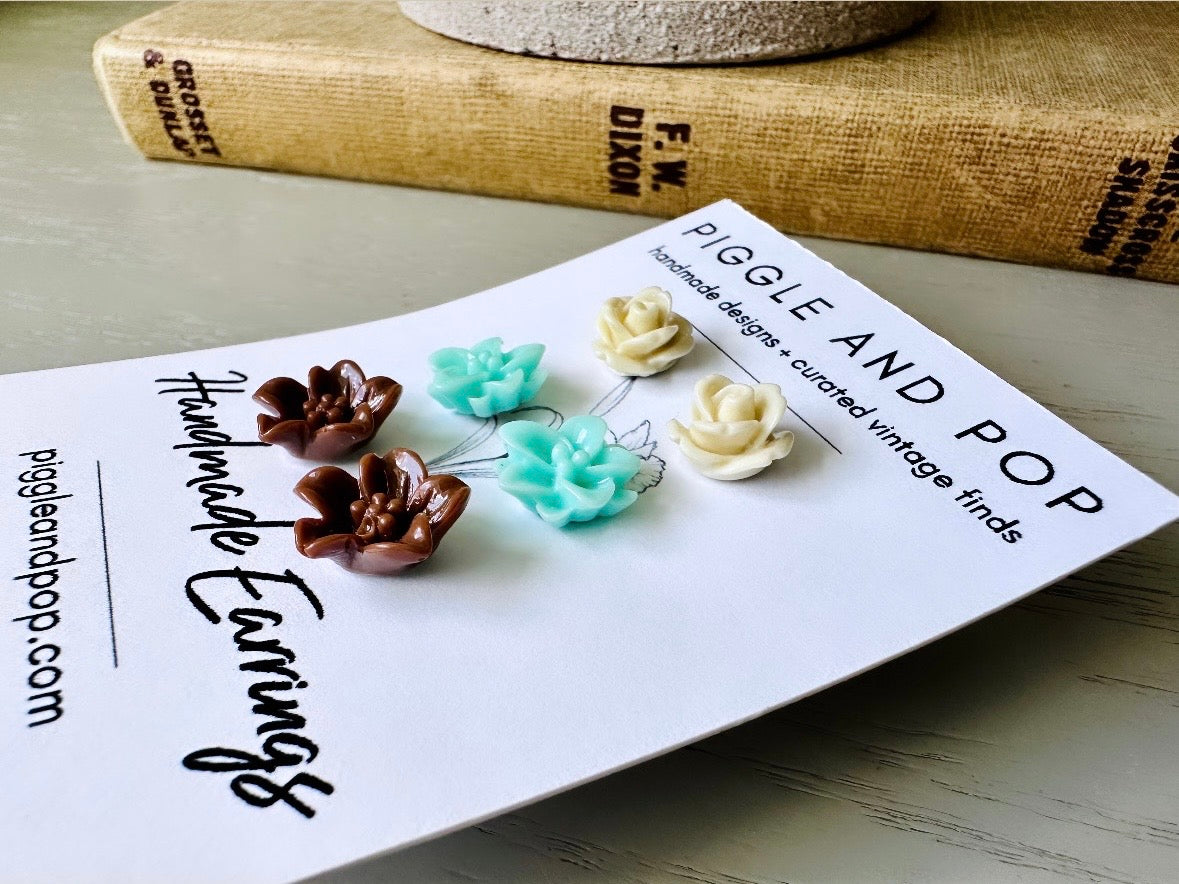 This listing is for three lovely pairs of handmade resin flower earrings. Cream roses, mint lotuses and chocolate brown lilies are paired up in a chic feminine set. These semi- glossy floral earrings are mounted on hypoallergenic surgical steel posts with butterfly backs. Dressed up or down, they are perfect for any occasion!