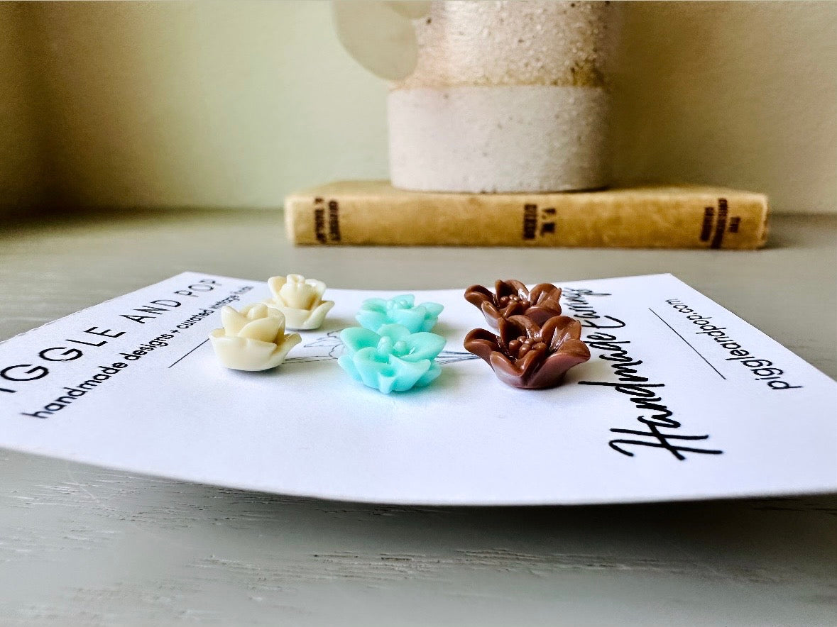 This listing is for three lovely pairs of handmade resin flower earrings. Cream roses, mint lotuses and chocolate brown lilies are paired up in a chic feminine set. These semi- glossy floral earrings are mounted on hypoallergenic surgical steel posts with butterfly backs. Dressed up or down, they are perfect for any occasion!