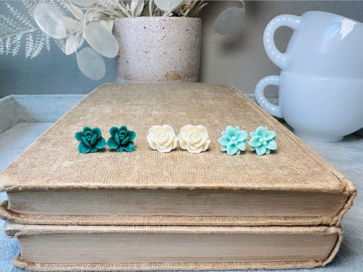 This green and mint flower stud earrings set is a wonderful addition to your jewelry box. This earring set features three pairs of resin flower earrings: emerald orchid earrings with a matte finish, creamy bloomed rose earrings and aqua lotus earrings. These pretty flower earrings feature hypoallergenic surgical steel posts and butterfly backs. Dressed up or down, they are perfect for any occasion!