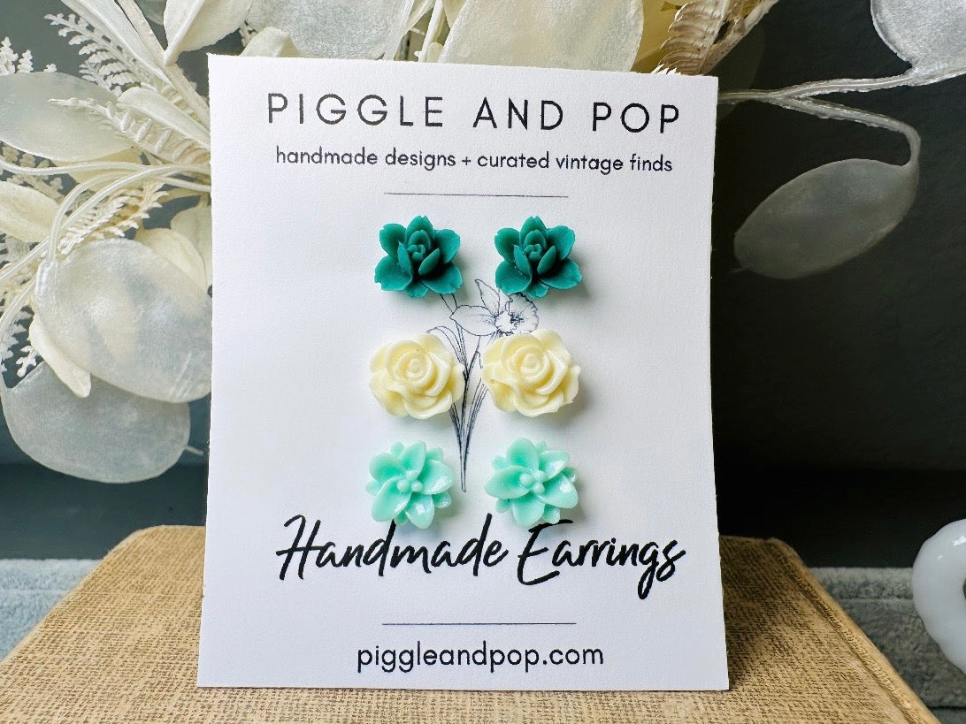 This green and mint flower stud earrings set is a wonderful addition to your jewelry box. This earring set features three pairs of resin flower earrings: emerald orchid earrings with a matte finish, creamy bloomed rose earrings and aqua lotus earrings. These pretty flower earrings feature hypoallergenic surgical steel posts and butterfly backs. Dressed up or down, they are perfect for any occasion!