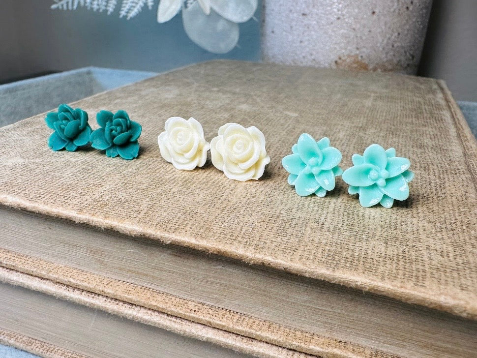 This green and mint flower stud earrings set is a wonderful addition to your jewelry box. This earring set features three pairs of resin flower earrings: emerald orchid earrings with a matte finish, creamy bloomed rose earrings and aqua lotus earrings. These pretty flower earrings feature hypoallergenic surgical steel posts and butterfly backs. Dressed up or down, they are perfect for any occasion!