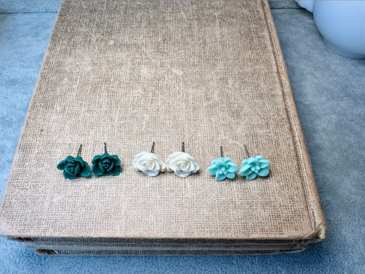 This green and mint flower stud earrings set is a wonderful addition to your jewelry box. This earring set features three pairs of resin flower earrings: emerald orchid earrings with a matte finish, creamy bloomed rose earrings and aqua lotus earrings. These pretty flower earrings feature hypoallergenic surgical steel posts and butterfly backs. Dressed up or down, they are perfect for any occasion!