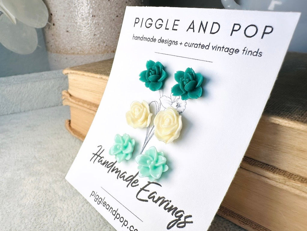 This green and mint flower stud earrings set is a wonderful addition to your jewelry box. This earring set features three pairs of resin flower earrings: emerald orchid earrings with a matte finish, creamy bloomed rose earrings and aqua lotus earrings. These pretty flower earrings feature hypoallergenic surgical steel posts and butterfly backs. Dressed up or down, they are perfect for any occasion!