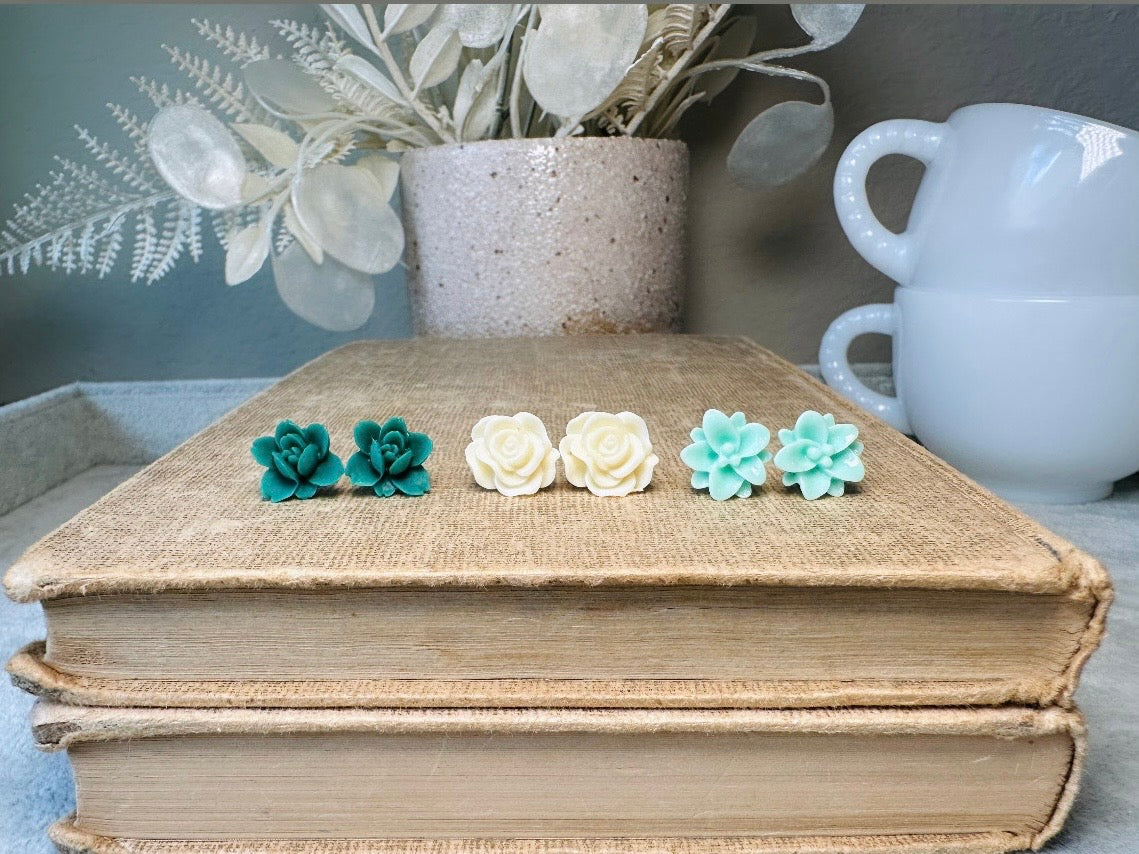 This green and mint flower stud earrings set is a wonderful addition to your jewelry box. This earring set features three pairs of resin flower earrings: emerald orchid earrings with a matte finish, creamy bloomed rose earrings and aqua lotus earrings. These pretty flower earrings feature hypoallergenic surgical steel posts and butterfly backs. Dressed up or down, they are perfect for any occasion!