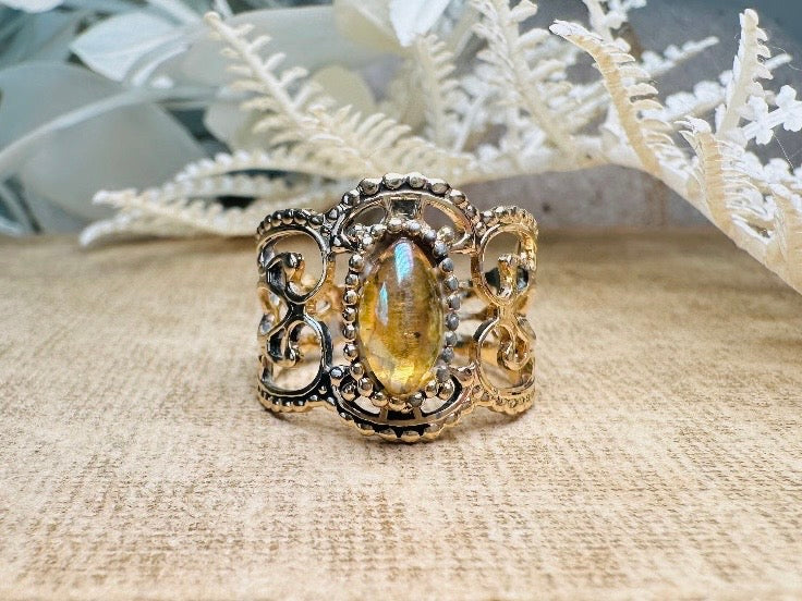 This 1970s Victorian revival vintage filigree ring is gorgeous. Featuring a faux fire opal cabochon stone set in a gold dotted bezel, the base of the ring is a beautiful open work lace filigree in an antique gold. High quality and strong filigree. Marked Sarah Coventry from 1970s.