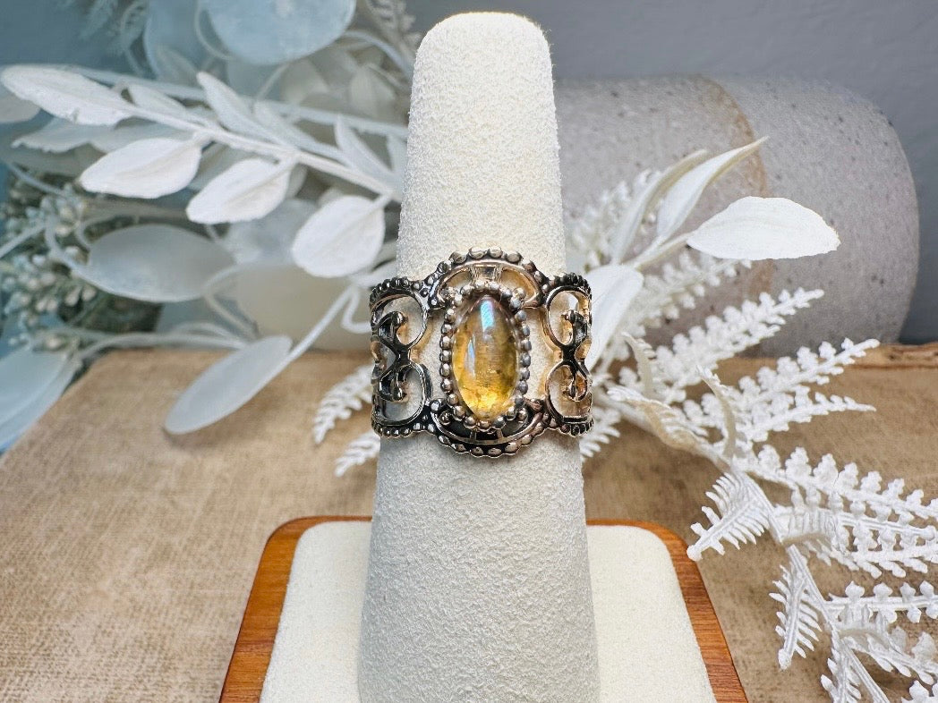 This 1970s Victorian revival vintage filigree ring is gorgeous. Featuring a faux fire opal cabochon stone set in a gold dotted bezel, the base of the ring is a beautiful open work lace filigree in an antique gold. High quality and strong filigree. Marked Sarah Coventry from 1970s.