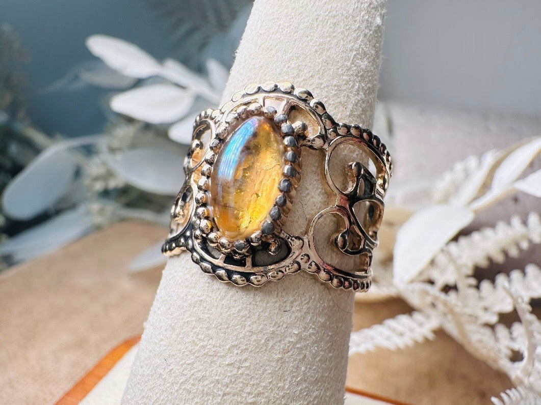 This 1970s Victorian revival vintage filigree ring is gorgeous. Featuring a faux fire opal cabochon stone set in a gold dotted bezel, the base of the ring is a beautiful open work lace filigree in an antique gold. High quality and strong filigree. Marked Sarah Coventry from 1970s.