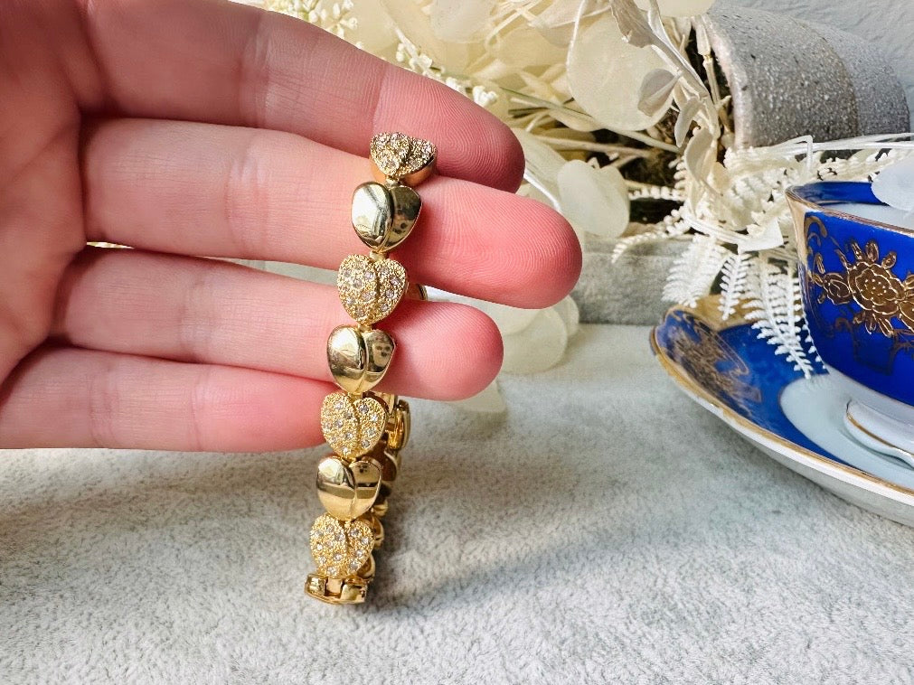 This sparkling rhinestone and gold heart bracelet is so darling. Featuring smooth gold hearts alternating with pave set rhinestone heart links. A lovely classic little bracelet. 