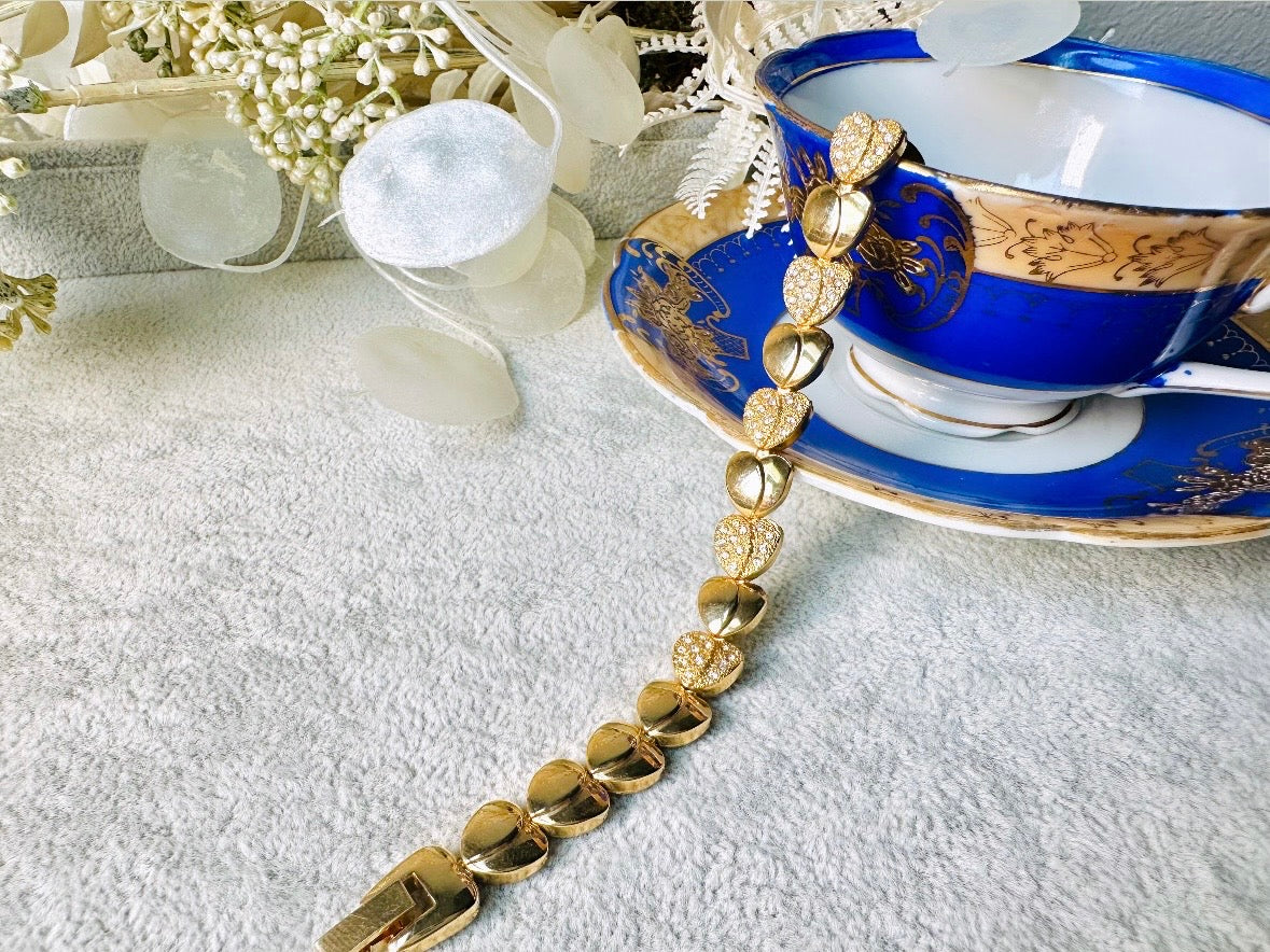 This sparkling rhinestone and gold heart bracelet is so darling. Featuring smooth gold hearts alternating with pave set rhinestone heart links. A lovely classic little bracelet. 