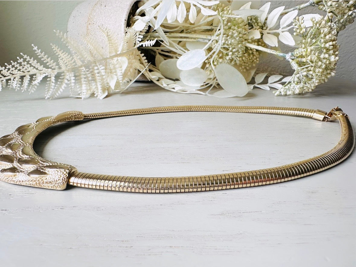 This gold omega necklace is a Park Lane signed designer vintage choker necklace from the 1980s. Featuring wide band gold snake chain with a textured raised geometric crescent bar, this gold collar necklace is bold and beautiful. In excellent vintage condition, signed Park Lane on back.