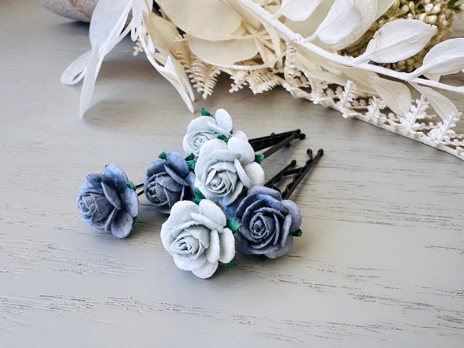 Six handmade rose hair pins with small grey paper flowers. The flowers are in shades of gray; three light silvery grey and three dark charcoal grey. The hair pins are dark bronze.