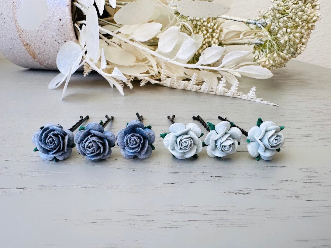 Six handmade rose hair pins with small grey paper flowers. The flowers are in shades of gray; three light silvery grey and three dark charcoal grey. The hair pins are dark bronze.