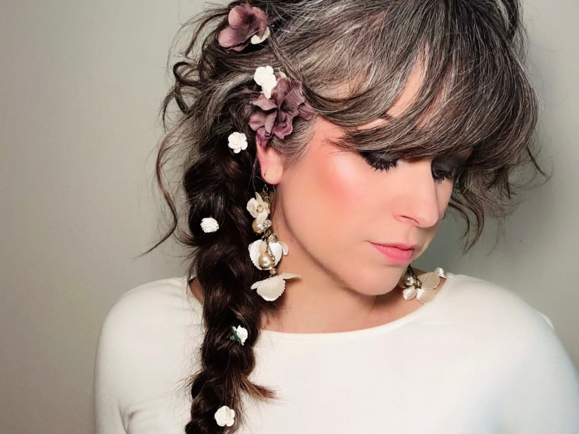 Styling possibilities with Piggle and Pop's handmade hair pins. Model is wearing the paper rose hair pins in white scattered in a loose low side braid.