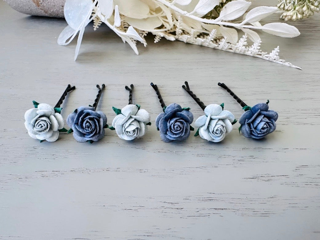 Six handmade rose hair pins with small grey paper flowers. The flowers are in shades of gray; three light silvery grey and three dark charcoal grey. The hair pins are dark bronze.