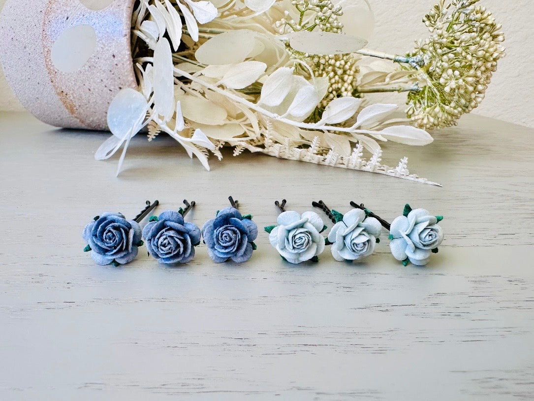 Six handmade rose hair pins with small grey paper flowers. The flowers are in shades of gray; three light silvery grey and three dark charcoal grey. The hair pins are dark bronze.