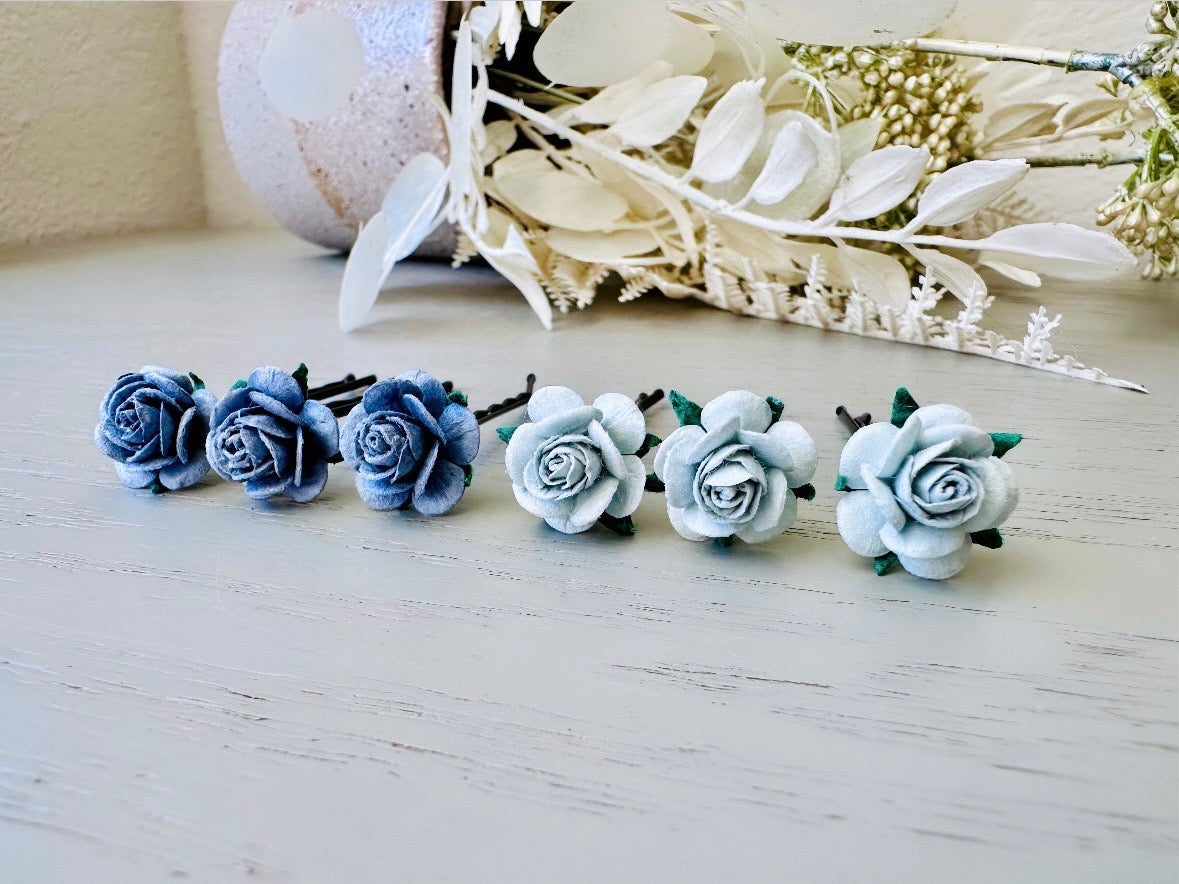 Six handmade rose hair pins with small grey paper flowers. The flowers are in shades of gray; three light silvery grey and three dark charcoal grey. The hair pins are dark bronze.