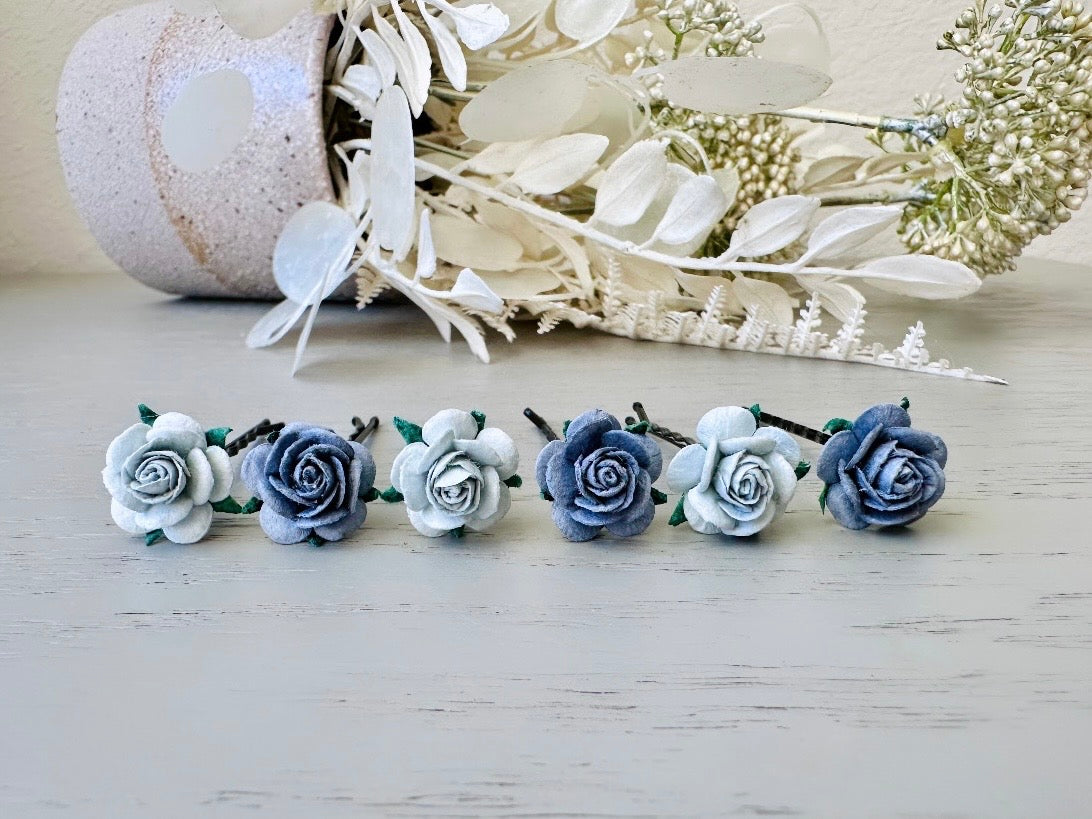 Six handmade rose hair pins with small grey paper flowers. The flowers are in shades of gray; three light silvery grey and three dark charcoal grey. The hair pins are dark bronze.