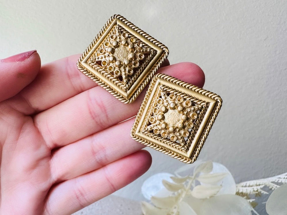 Matte Gold Filigree Square Lace Etruscan Style Earrings from Piggle and Pop held in hand