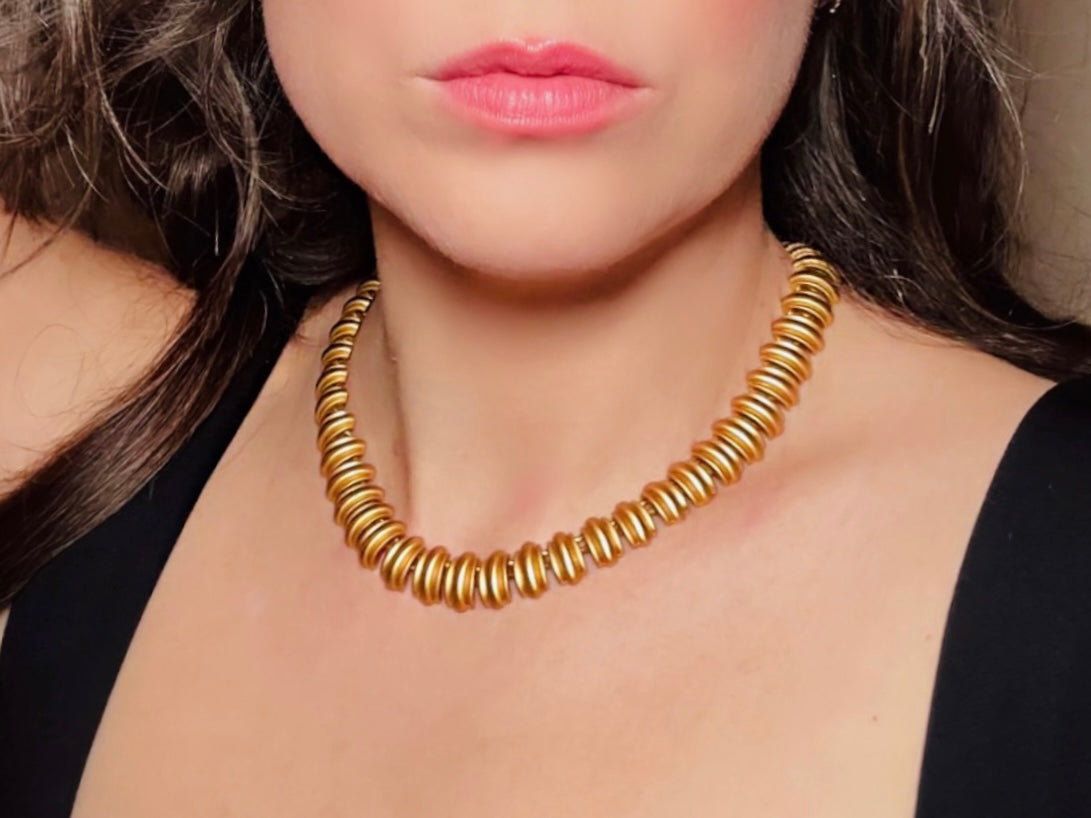 This vintage Anne Klein matte gold statement necklace is a beautiful classic satin gold collar necklace with articulated link segments.A signed AK piece, well known for superior quality and craftsmanship- this gold collar necklace is the perfect one to wear alone or pair with others for a spectacular stack. Toggle clasp at adjustable lengths. Modeled for size reference.