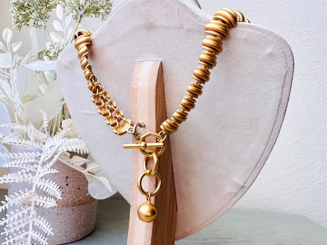 This vintage Anne Klein matte gold statement necklace is a beautiful classic satin gold collar necklace with articulated link segments.A signed AK piece, well known for superior quality and craftsmanship- this gold collar necklace is the perfect one to wear alone or pair with others for a spectacular stack. Toggle clasp at adjustable lengths.