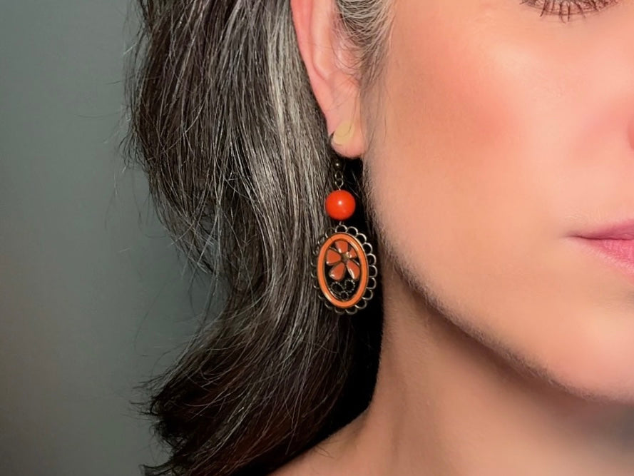 These orange flower enamel and bronze 70s vintage dangle earrings are fabulously funky. A lacey cameo featuring an orange enamel flower linked with a glossy orange bead. A very fun pair, the color is amazing- in great vintage condition, please view all pics.