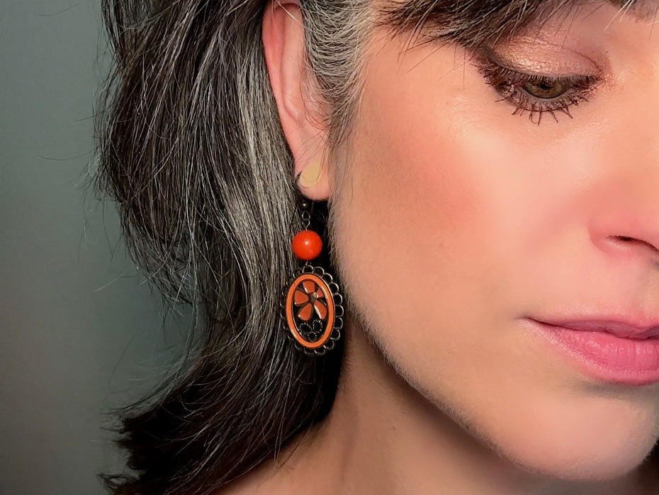 These orange flower enamel and bronze 70s vintage dangle earrings are fabulously funky. A lacey cameo featuring an orange enamel flower linked with a glossy orange bead. A very fun pair, the color is amazing- in great vintage condition, please view all pics.