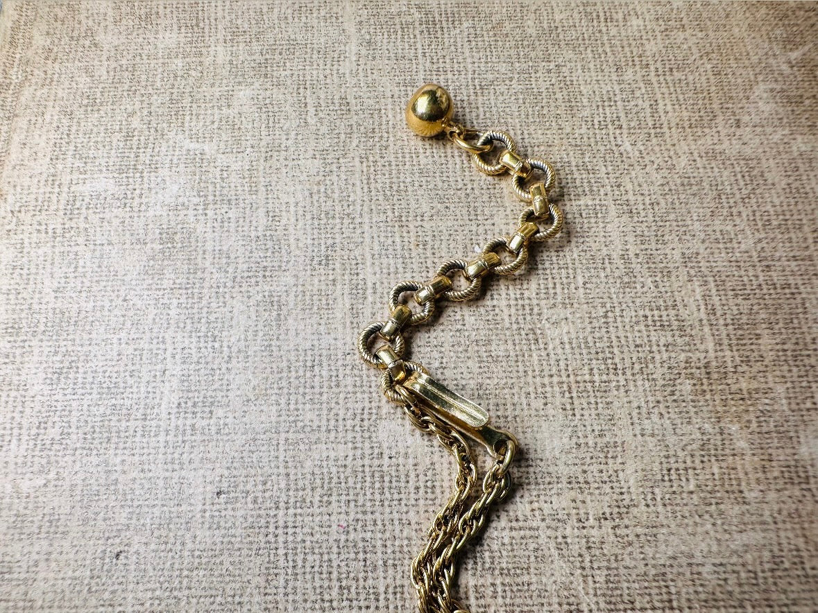 This vintage signed Crown Trifari Jelly Belly Owl necklace is a fantastic find! Gold tone twisted cable chain hosts a small intricate owl pendant with eye cut outs and a glowing chocolate brown lucite belly. These necklaces are highly collectible and hard to find with their original chains. From the 1960s. In great condition, with minimal wear from age, no major flaws to note.