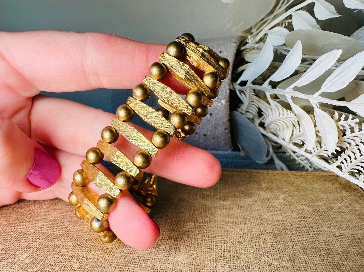 This bold 1970s vintage gold bracelet is so unique- featuring brushed gold bars and smooth polished gold beads. This chunky gold bracelet is timeless and would pair well with a variety of other pieces. An unsigned one of a kind bracelet and perfect jewelry gift for the vintage lover. Structural geometric pieces are currently trending. In great vintage condition, some very minor gold wear on hinge clip- please view all pics.