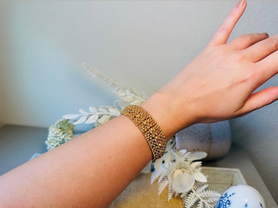This vintage articulated chunky gold panel bracelet is a showstopper. This signed SC bracelet features articulated gold plated panels with a raised stipple texture throughout. Incredibly well made an in excellent vintage condition. Fastens with a fold over hinge clasp and looks incredible on its own or paired with others for a sensational stack. No flaws to note, please see all pics, from 1973.
Dimensions: 7.75" long, 0.75" wide. Fold over clasp closure.