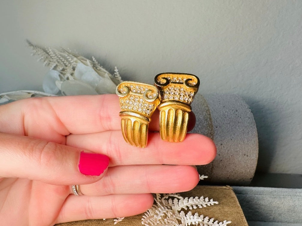 These vintage gold Carolee Roman column earrings are an incredible pair of bold neoclassical earrings. Featuring a matte gold finish, these clip on style sculptural earrings are accented with tiny pave set rhinestones. An incredible pair of signed designer earrings from the 1980s. A truly striking vintage treasure. Please view all pics and let me know if you have any questions at all!