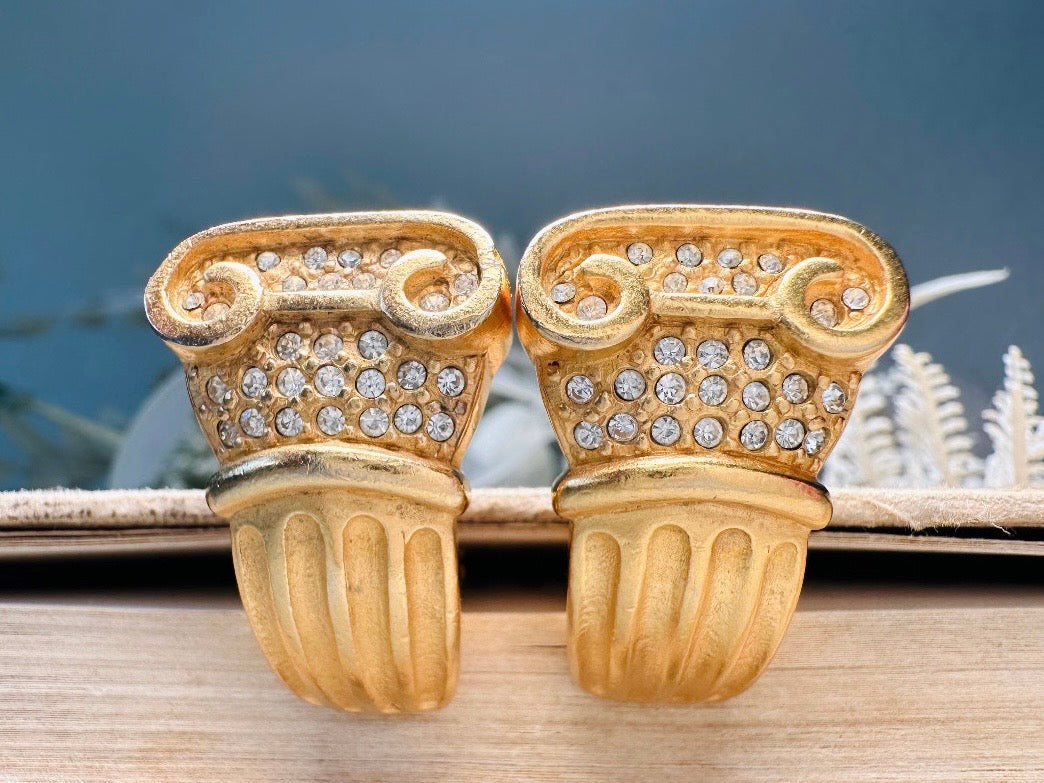 These vintage gold Carolee Roman column earrings are an incredible pair of bold neoclassical earrings. Featuring a matte gold finish, these clip on style sculptural earrings are accented with tiny pave set rhinestones. An incredible pair of signed designer earrings from the 1980s. A truly striking vintage treasure. Please view all pics and let me know if you have any questions at all!