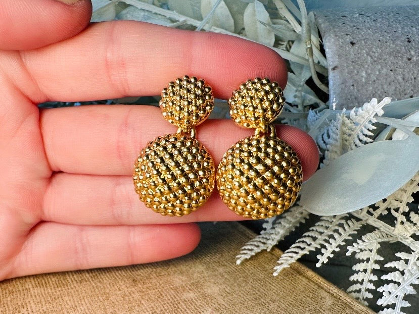 These vintage gold statement earrings are absolutely fabulous! Gold tone double dome drop earrings are chock full of interesting details. These earrings feature 2 large dome shaped gold components with a dotted "raspberry" texture- just so stunning! These earrings are such a classic 80s pair- bold and dramatic! In great vintage condition -no major flaws to note- please see pics. Signed Avon- pierced style!