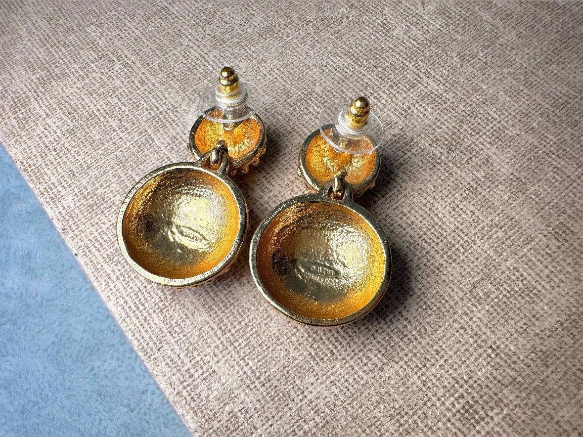 These vintage gold statement earrings are absolutely fabulous! Gold tone double dome drop earrings are chock full of interesting details. These earrings feature 2 large dome shaped gold components with a dotted "raspberry" texture- just so stunning! These earrings are such a classic 80s pair- bold and dramatic! In great vintage condition -no major flaws to note- please see pics. Signed Avon- pierced style!