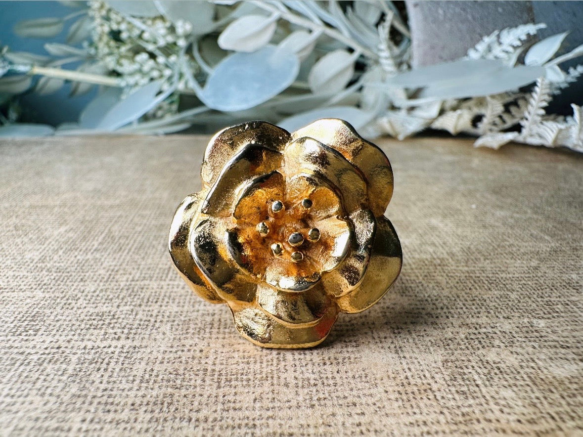 This bold vintage gold magnolia ring from Piggle and Pop is an incredible statement piece. Featuring a chunky gold base and blooming oversized magnolia, this sculptural flower ring is a stunning cocktail ring. Pair is with others for a fun maximalist look or let it shine on its own. This ring is stamped 8 for its size but is unmarked to its maker. A solid well made piece in excellent vintage condition.
Dimensions: fitted US size 8