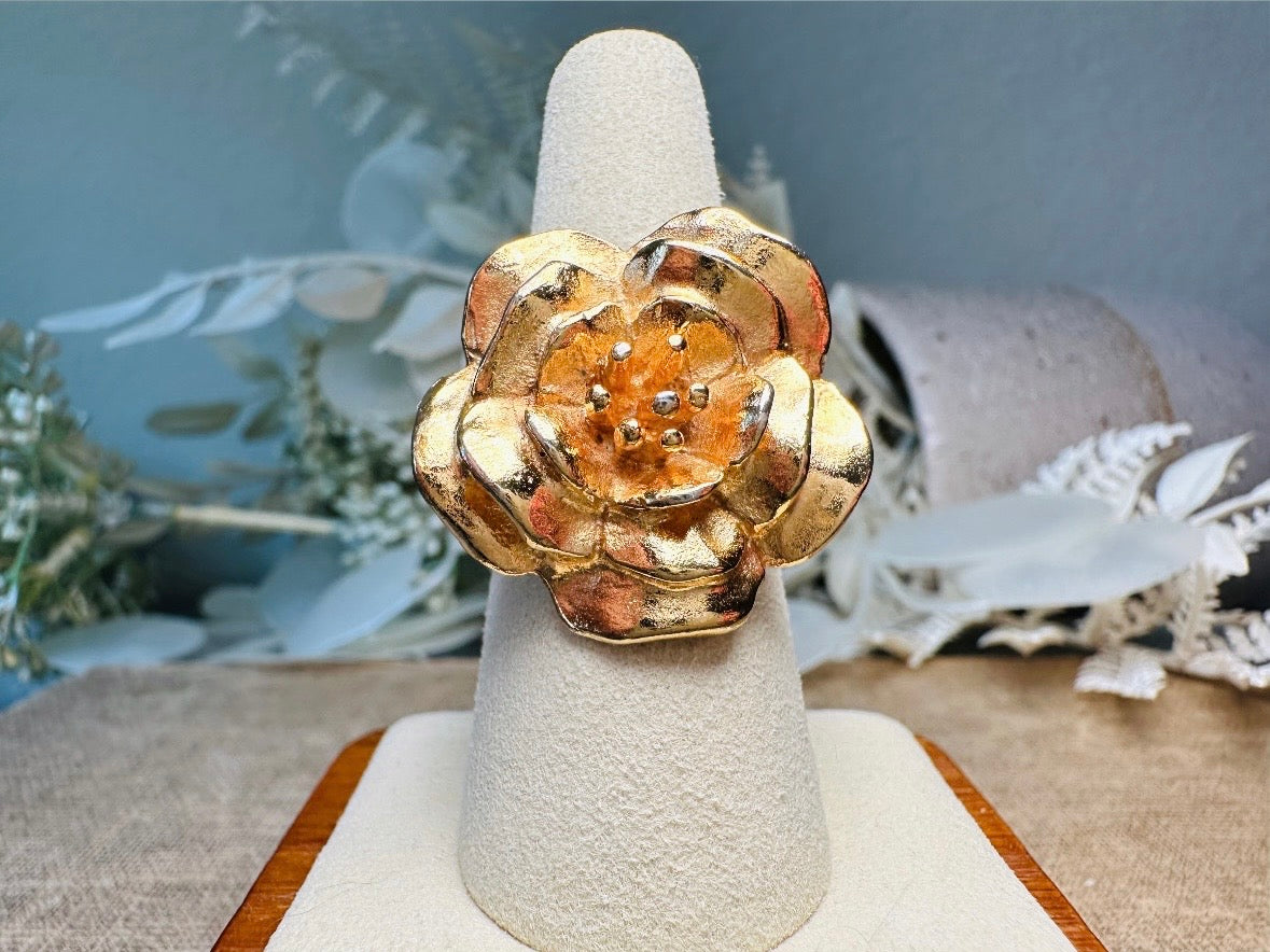 This bold vintage gold magnolia ring from Piggle and Pop is an incredible statement piece. Featuring a chunky gold base and blooming oversized magnolia, this sculptural flower ring is a stunning cocktail ring. Pair is with others for a fun maximalist look or let it shine on its own. This ring is stamped 8 for its size but is unmarked to its maker. A solid well made piece in excellent vintage condition.
Dimensions: fitted US size 8