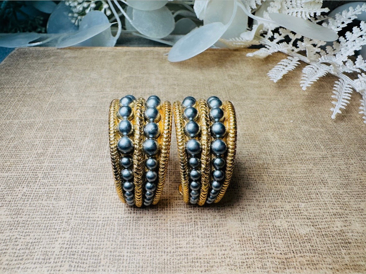 These oversized gold hoop vintage statement earrings feature two rows of chanel set dark silver pearls in graduating size, the sides are a beautiful roped texture. These dark silver pearl and gold half hoop earrings are huggie hoop style- these clip ons effortlessly add a touch of bold glam the 80s are so beloved for. A beautiful textured finish, the contrast of cool silver pearls and classic gold- these earrings are a showstopping vintage pair, in excellent condition.