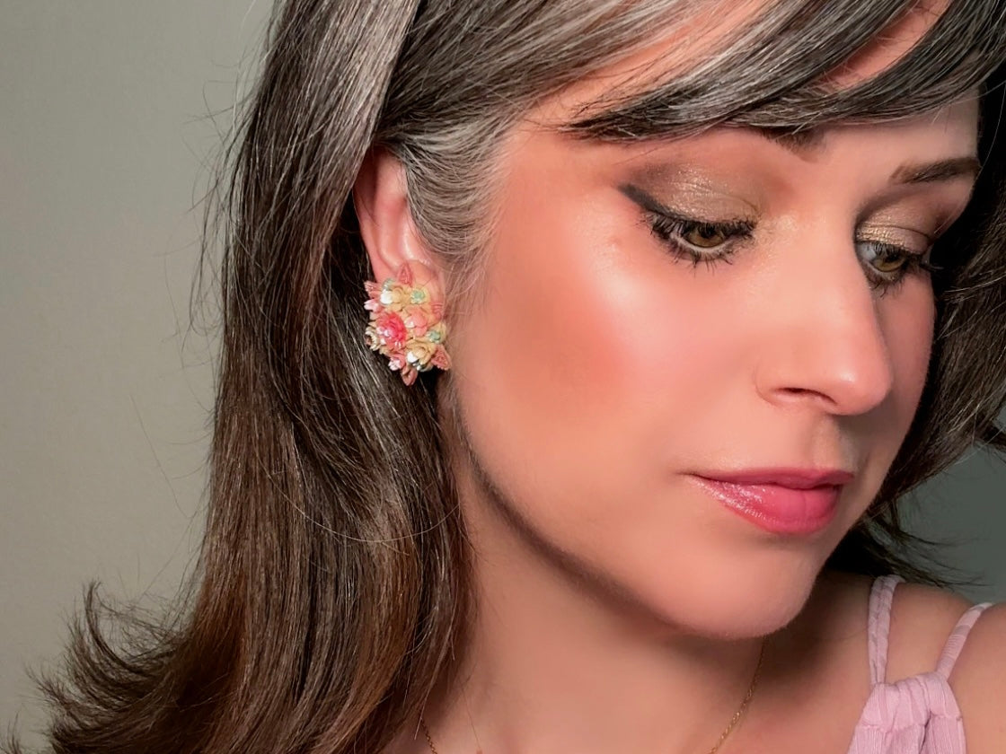 Shown on a model. These vintage 1950s Japanese floral celluloid earrings are so colorful. Carved celluloid bursting with sakura blossoms and flowers, these earrings are on the larger side and are painted with a beautiful pearlized pink, blue and light cream. The star-shaped base and raised beaded edges are also characteristic of vintage Japanese celluloid jewelry. They are 1.5" in size.