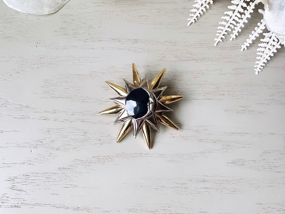 This is a vintage Liz Claiborne moon and starburst brooch from the 1980s. In excellent condition, this pin features a silver and gold starburst with a silver crescent moon on top of black circular enamel inlay. High quality designer signed brooch. No flaws to note, this vintage brooch has a fully working pin and lock, in great condition.